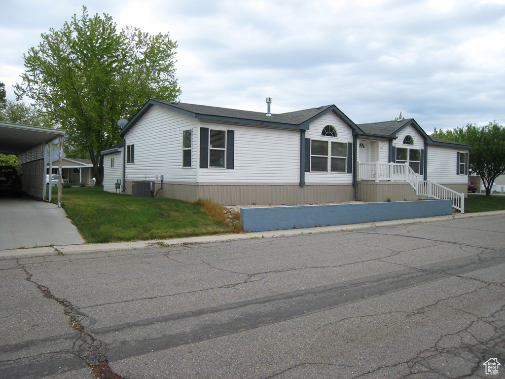 Manufactured / mobile home with central AC, a front yard, and driveway