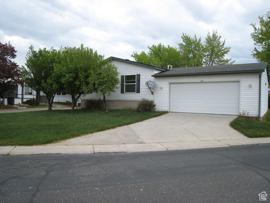 Single story home featuring a front yard, a garage, and driveway