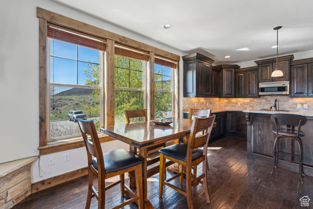 Dining room with recessed lighting, baseboards, and dark wood-style floors
