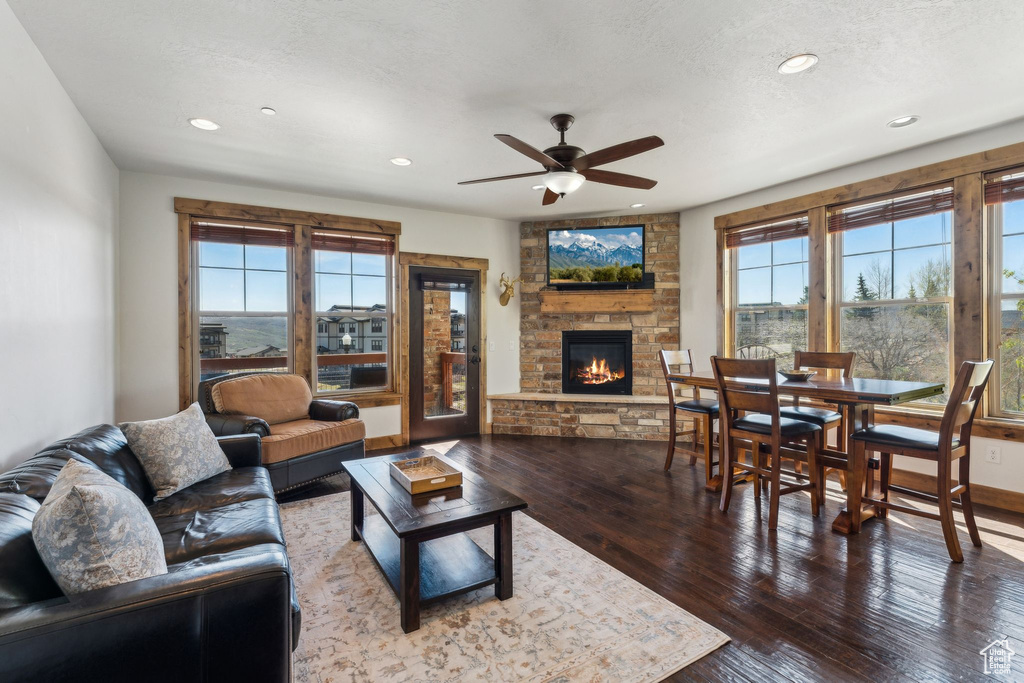 Living room with wood-type flooring, recessed lighting, ceiling fan, and a fireplace