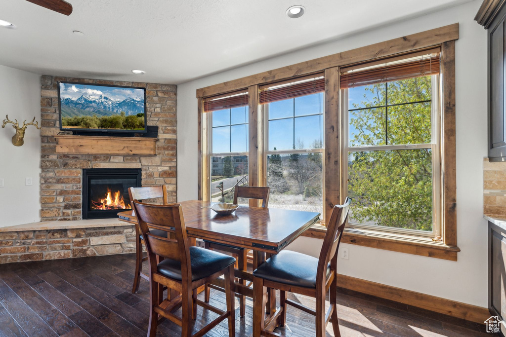 Dining area featuring a fireplace, recessed lighting, dark wood-style floors, and plenty of natural light