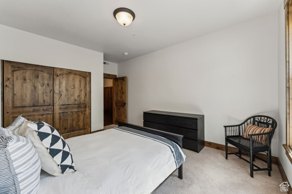 Bedroom featuring baseboards and light colored carpet