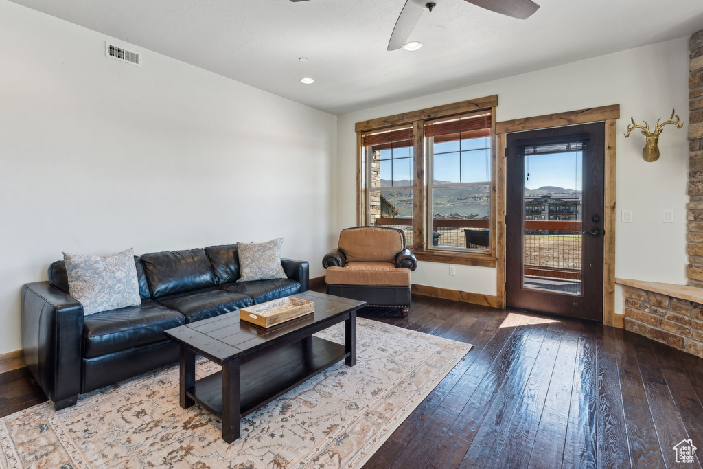 Living room featuring visible vents, wood-type flooring, ceiling fan, and baseboards