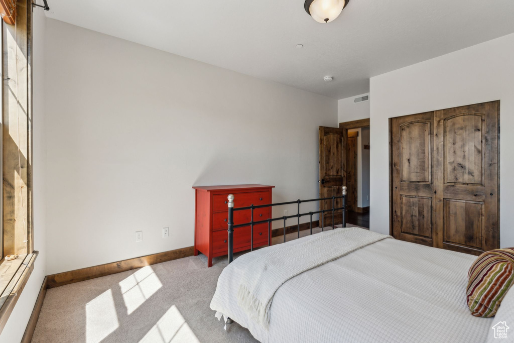 Carpeted bedroom with baseboards and visible vents