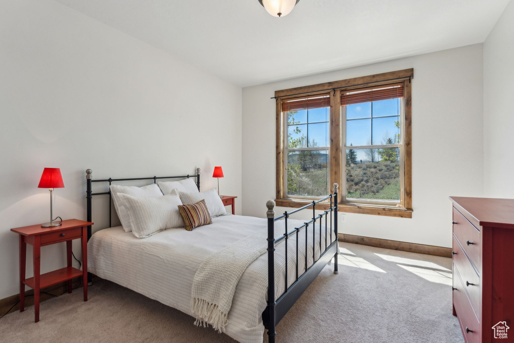 Bedroom with baseboards and light colored carpet