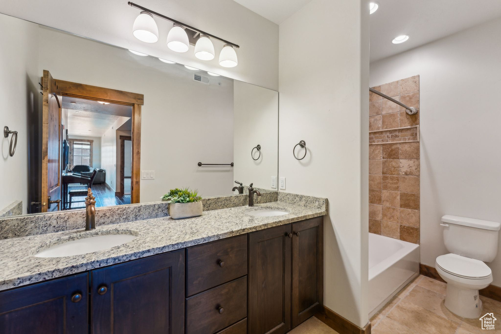 Bathroom featuring a sink, toilet, double vanity, and visible vents
