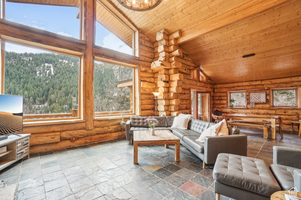 Living area featuring high vaulted ceiling, wood ceiling, and rustic walls