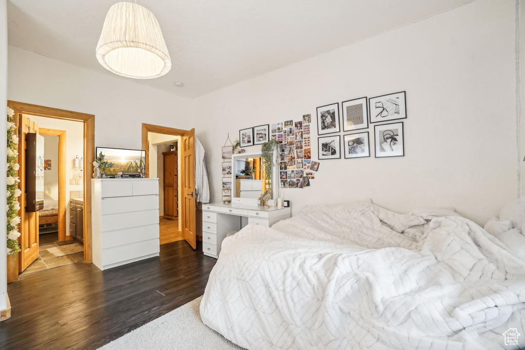 Bedroom with ensuite bath and dark wood-type flooring