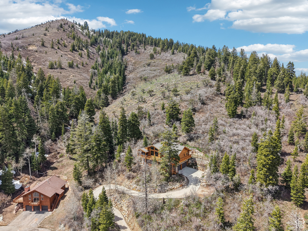 Birds eye view of property with a wooded view and a mountain view