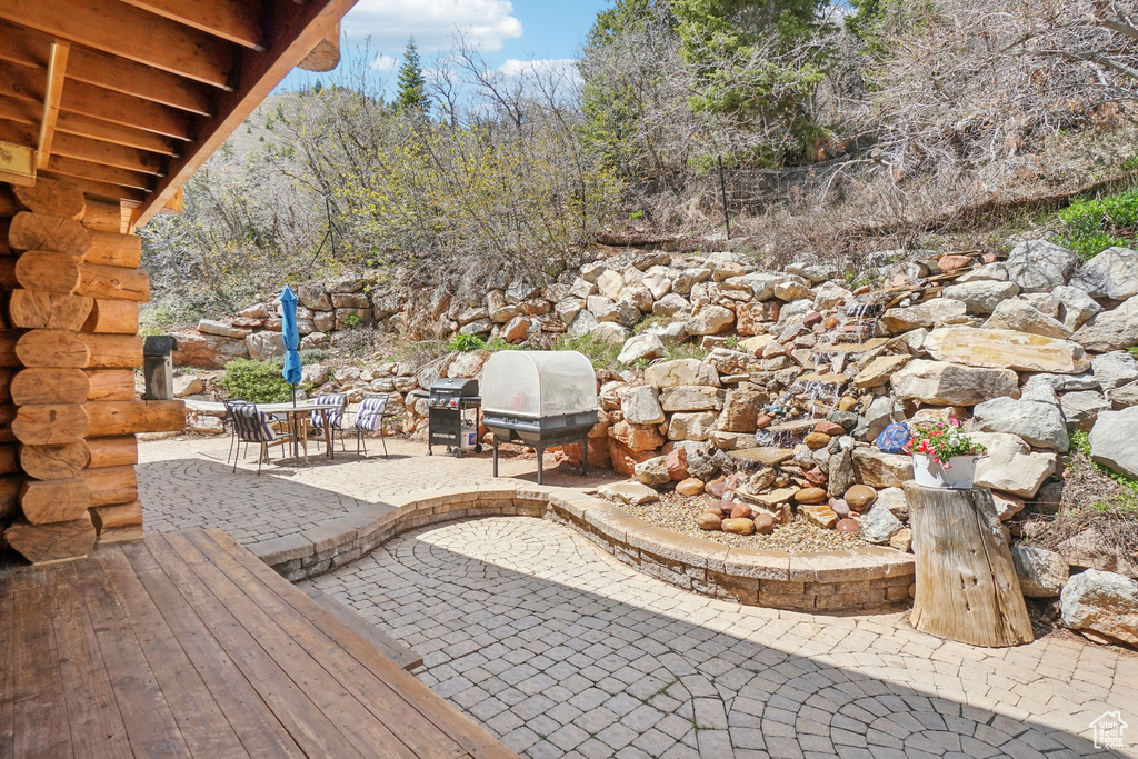 View of patio with a grill