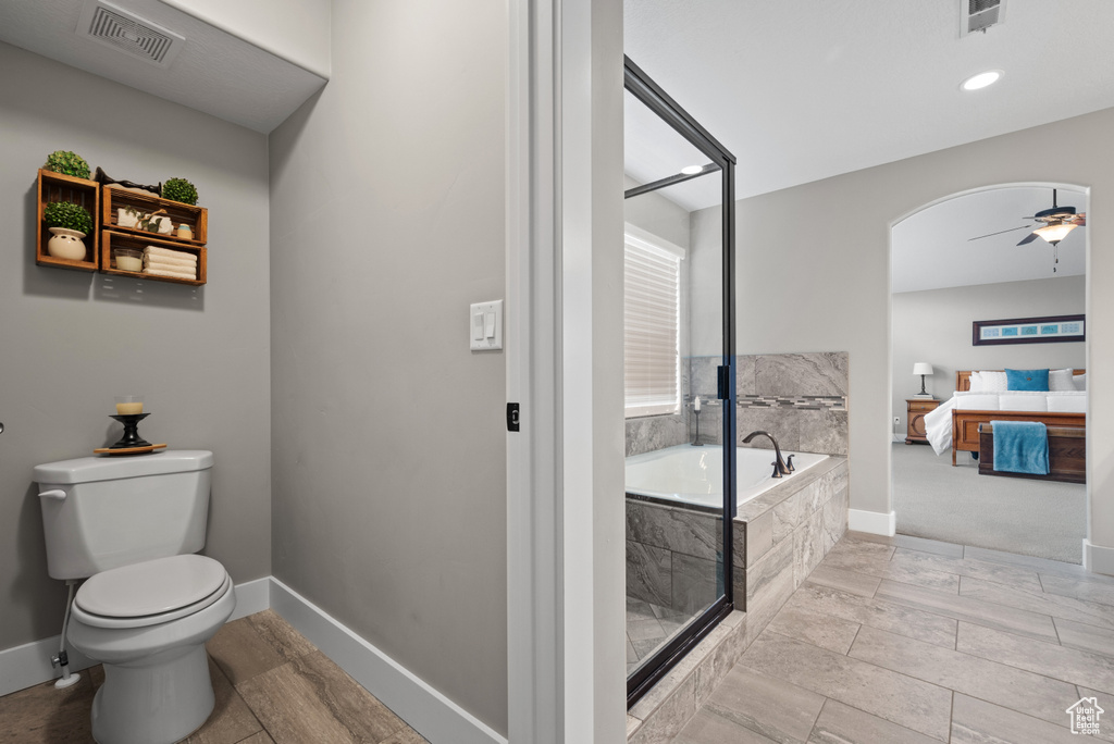 Full bath featuring toilet, ceiling fan, visible vents, and a bath
