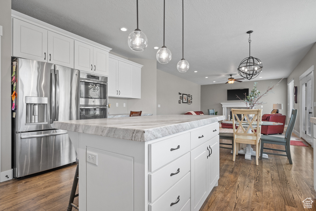Kitchen featuring appliances with stainless steel finishes, dark wood-style flooring, ceiling fan with notable chandelier, and recessed lighting