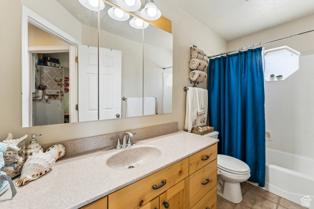 Full bathroom featuring toilet, vanity, and shower / bath combo with shower curtain