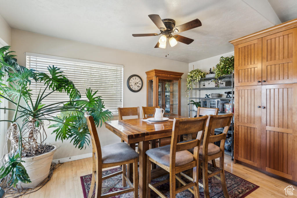 Dining area with light wood-style flooring and ceiling fan