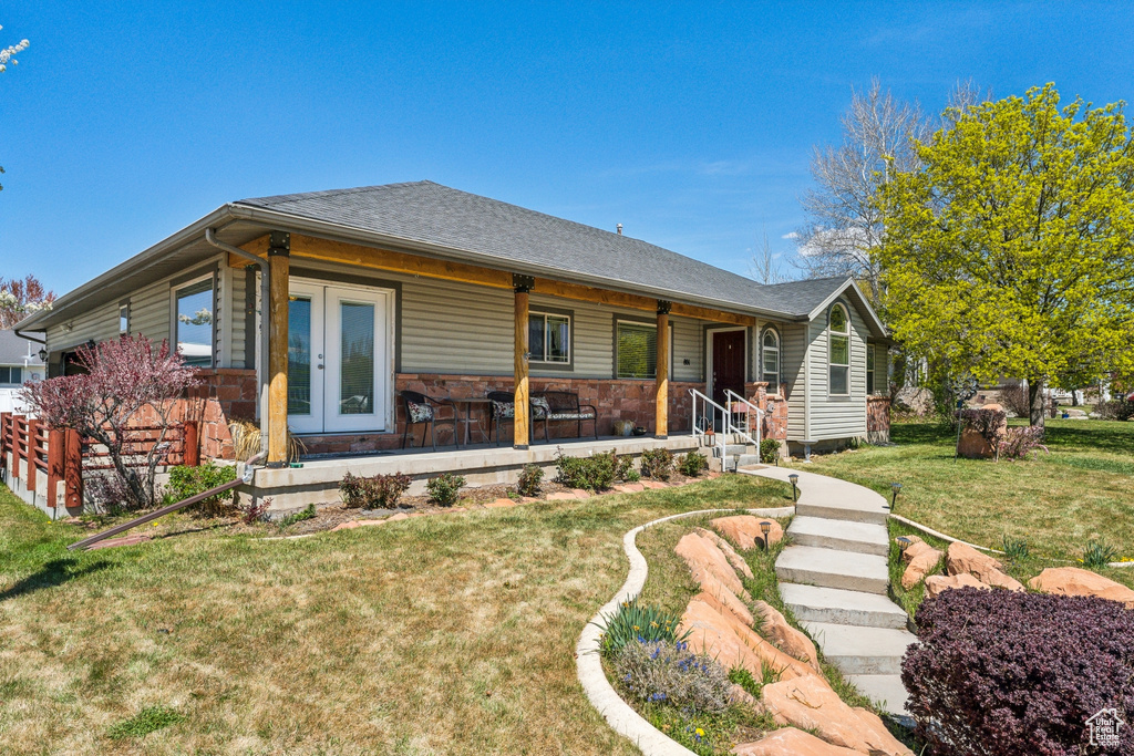 View of front of house with a porch and a front yard