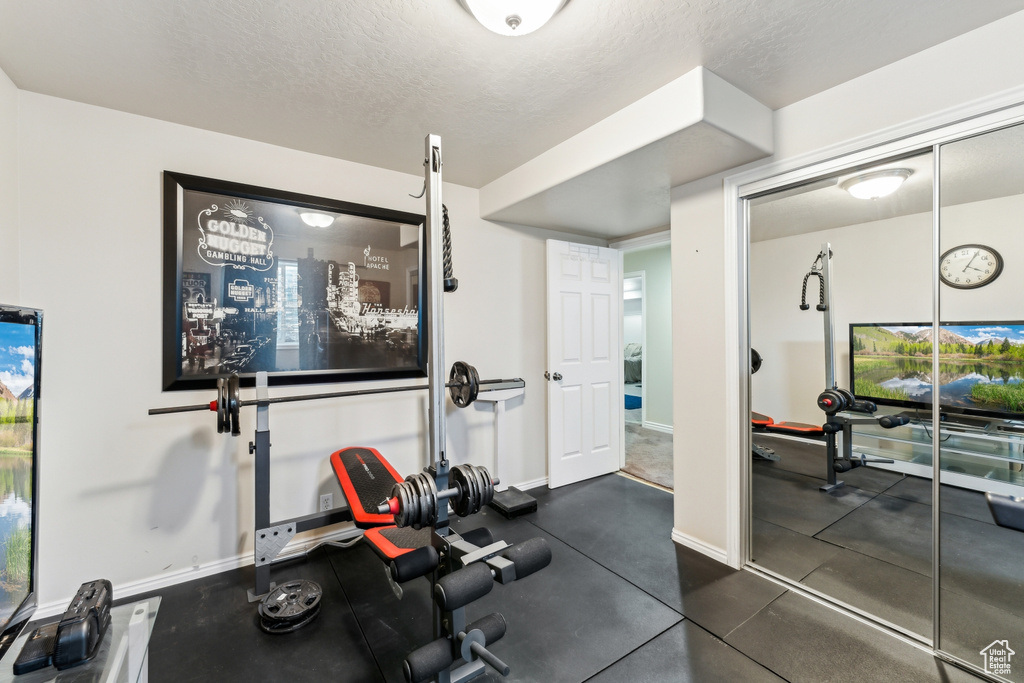 Workout area featuring baseboards and a textured ceiling