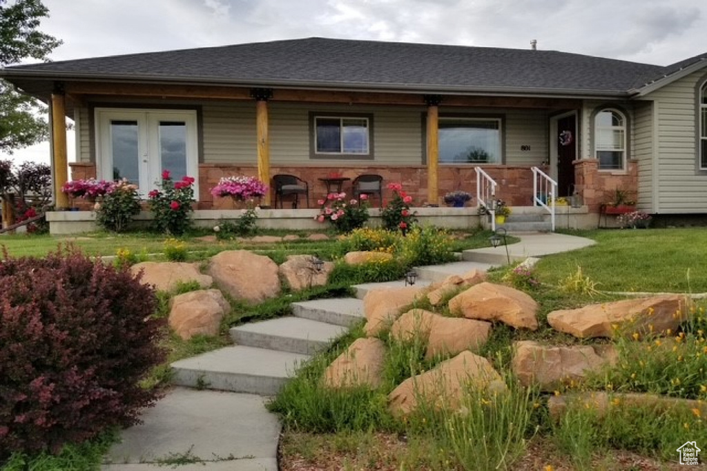 View of front of home featuring a porch, a front lawn, and a shingled roof