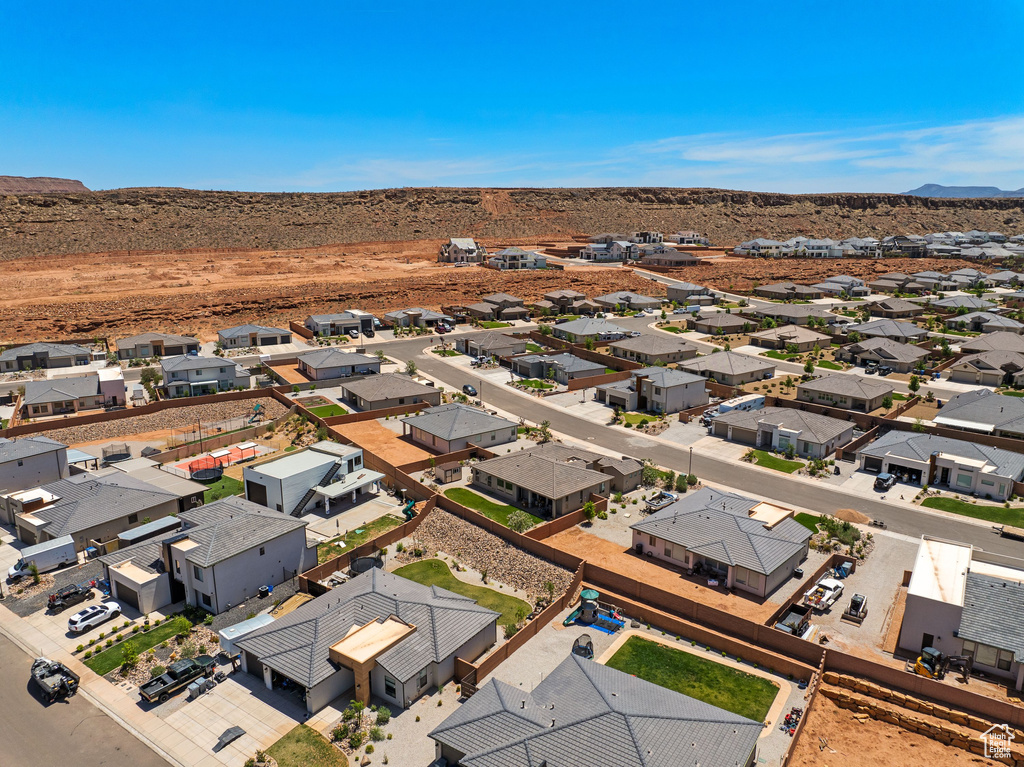 Aerial perspective of suburban area featuring a mountain backdrop and a desert landscape