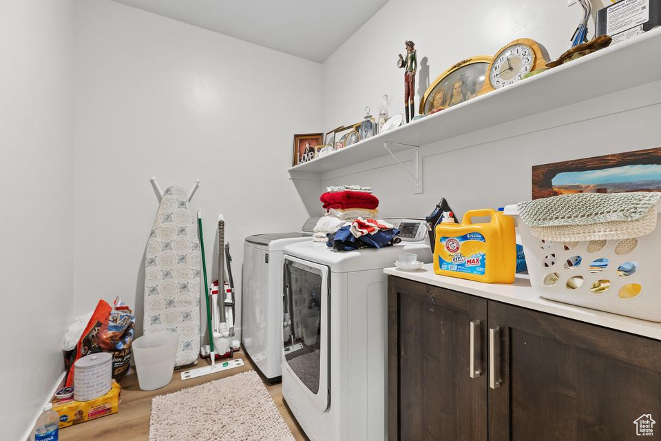 Laundry area featuring washer and clothes dryer and light wood-style flooring