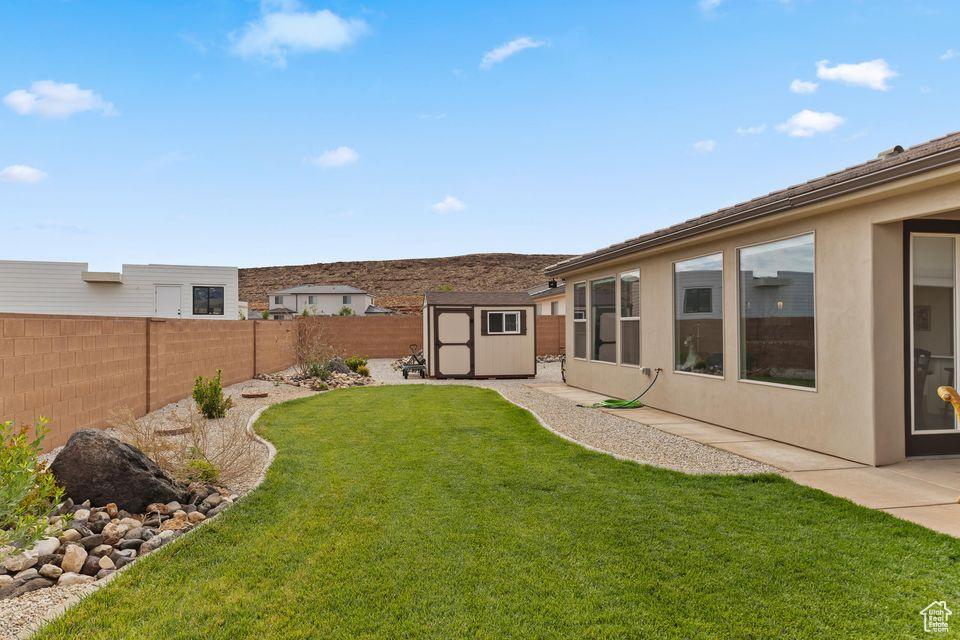 View of yard with a storage shed and an outdoor structure