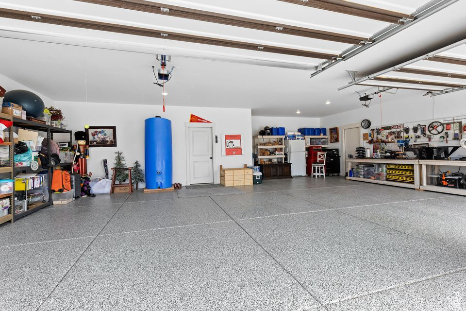 Garage with freestanding refrigerator and a workshop area