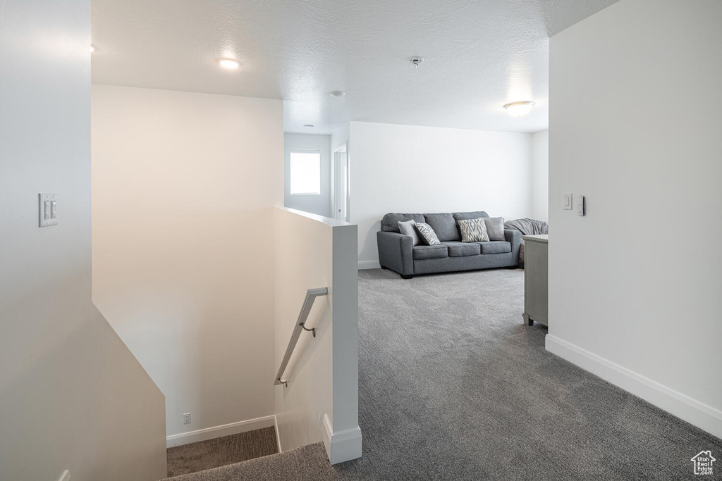 Hall featuring carpet floors, baseboards, and an upstairs landing