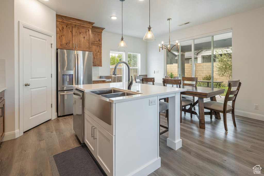 Kitchen featuring a center island with sink, visible vents, light countertops, appliances with stainless steel finishes, and recessed lighting