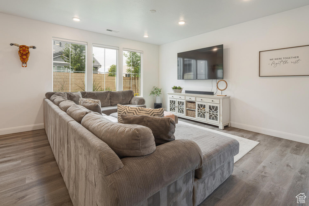 Living area with recessed lighting, baseboards, visible vents, and wood finished floors