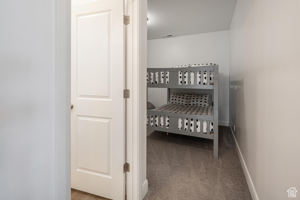 Carpeted bedroom featuring baseboards and visible vents