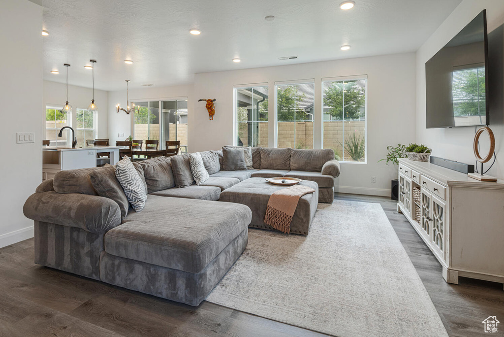 Living area featuring recessed lighting, baseboards, an inviting chandelier, visible vents, and dark wood-style floors