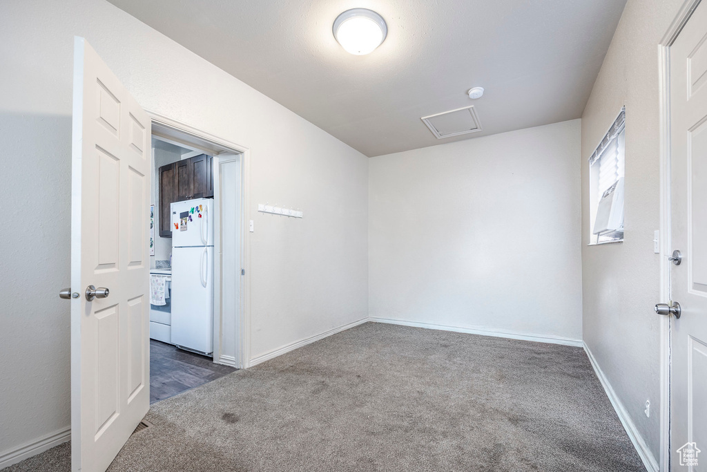 Unfurnished room with carpet flooring, baseboards, and attic access