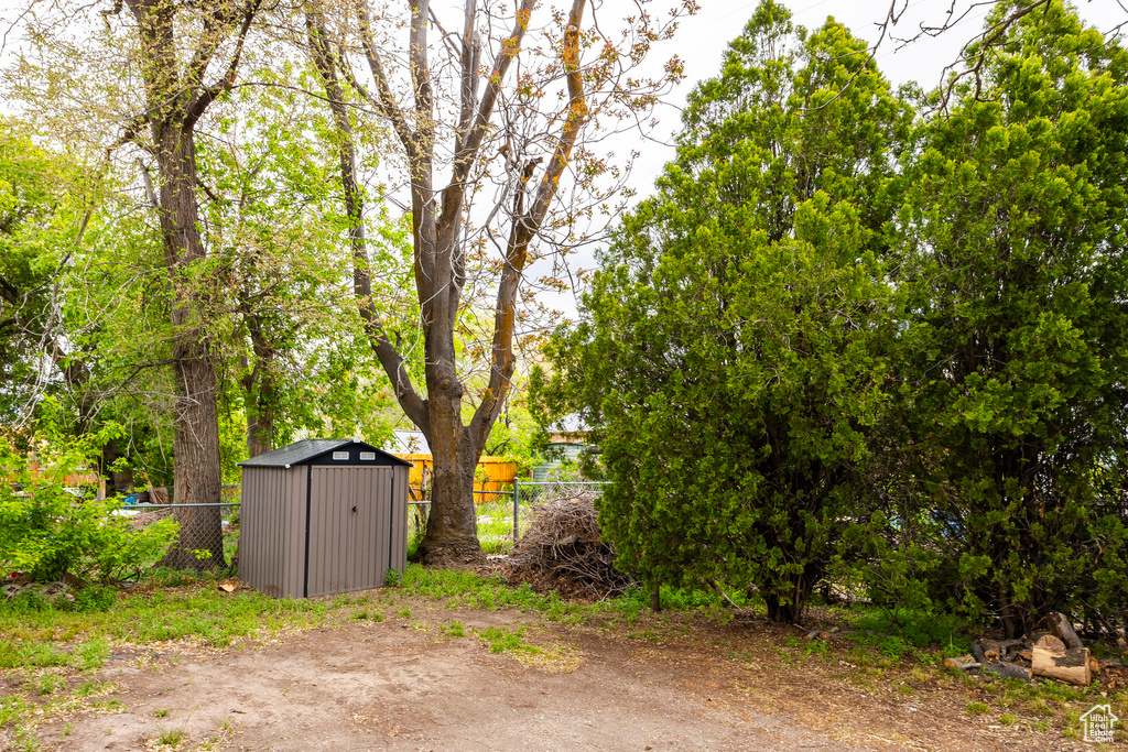 View of yard with an outdoor structure, a shed, and fence