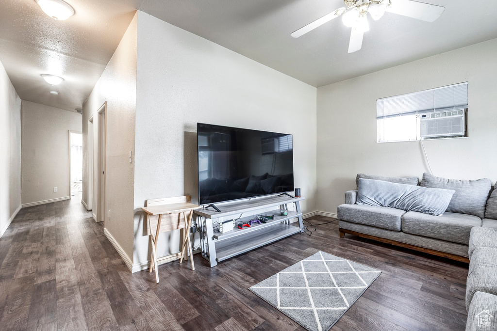 Living room with a ceiling fan, baseboards, and wood finished floors