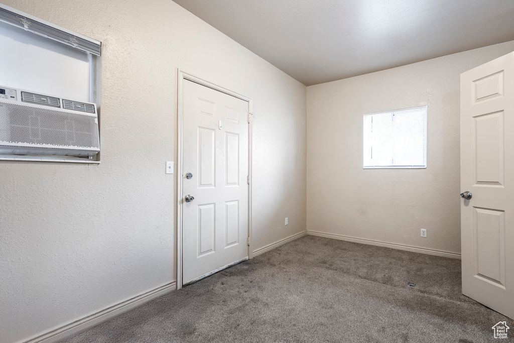 Carpeted spare room featuring baseboards