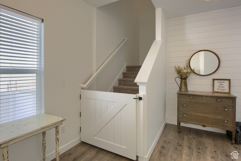 Stairway with wooden walls, baseboards, and wood finished floors