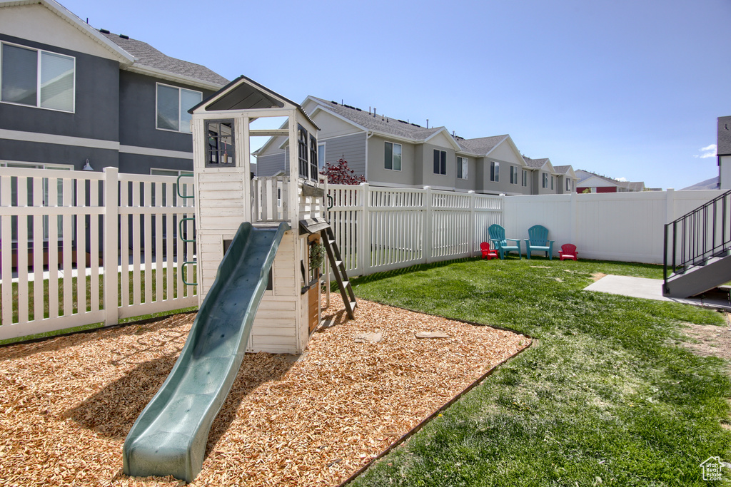 View of yard featuring a fenced backyard, a playground, and a residential view
