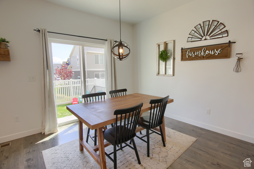 Dining room featuring baseboards, dark wood finished floors, a healthy amount of sunlight, and visible vents