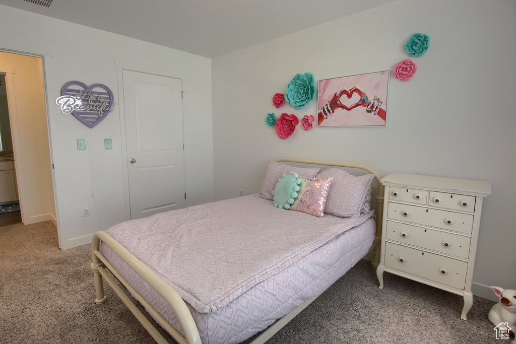 Carpeted bedroom featuring baseboards and visible vents