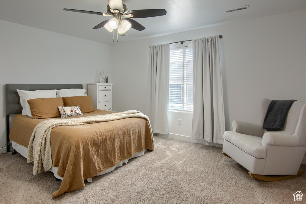 Bedroom featuring visible vents, a ceiling fan, baseboards, and light carpet