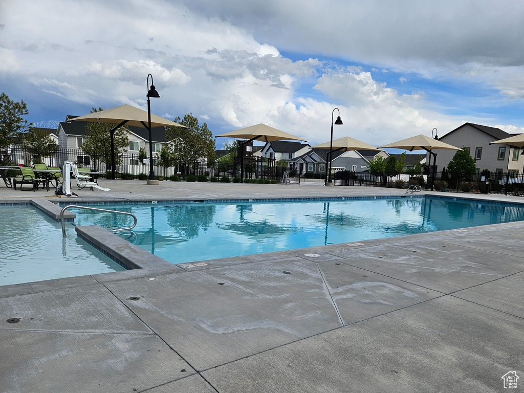 Community pool featuring a residential view, fence, and a patio