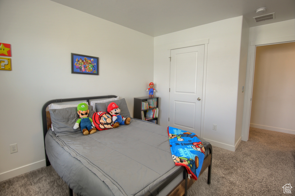 Carpeted bedroom featuring baseboards and visible vents
