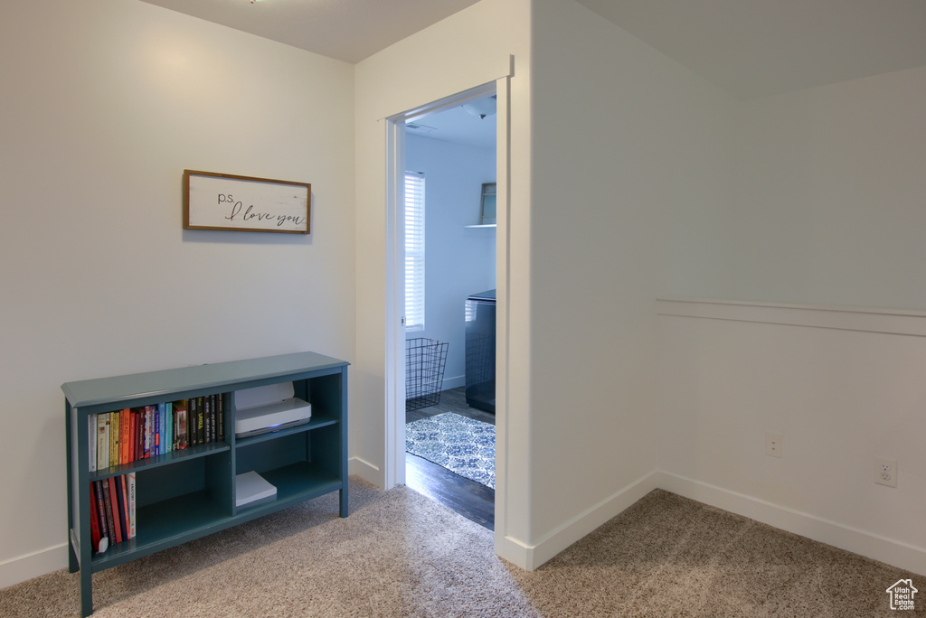Corridor featuring baseboards and carpet flooring