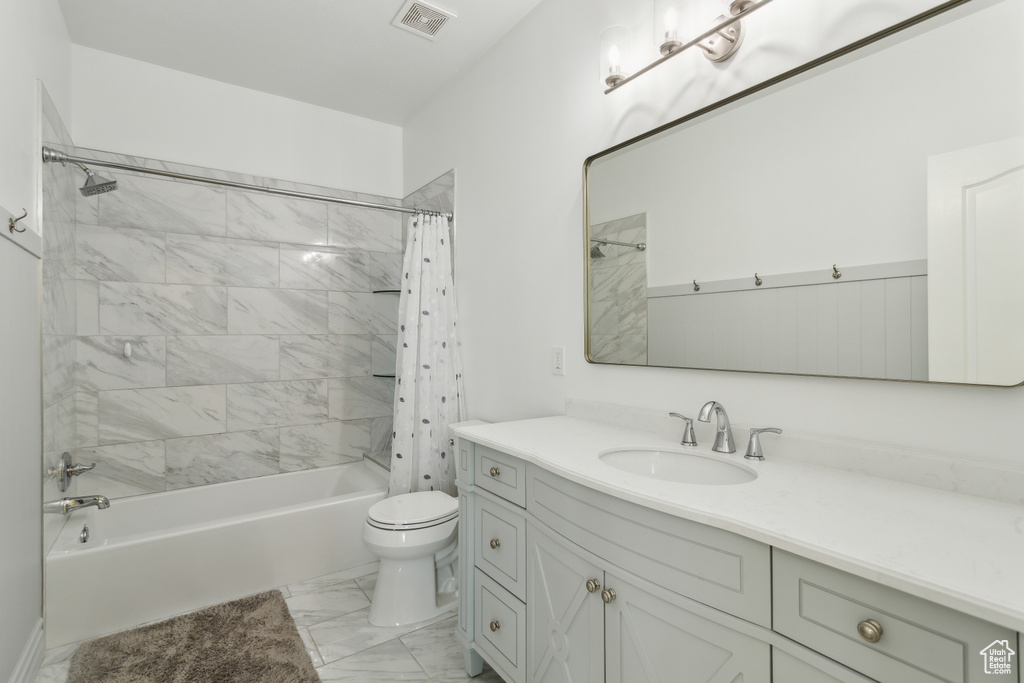 Bathroom featuring visible vents, vanity, marble finish floor, toilet, and shower / bath combo