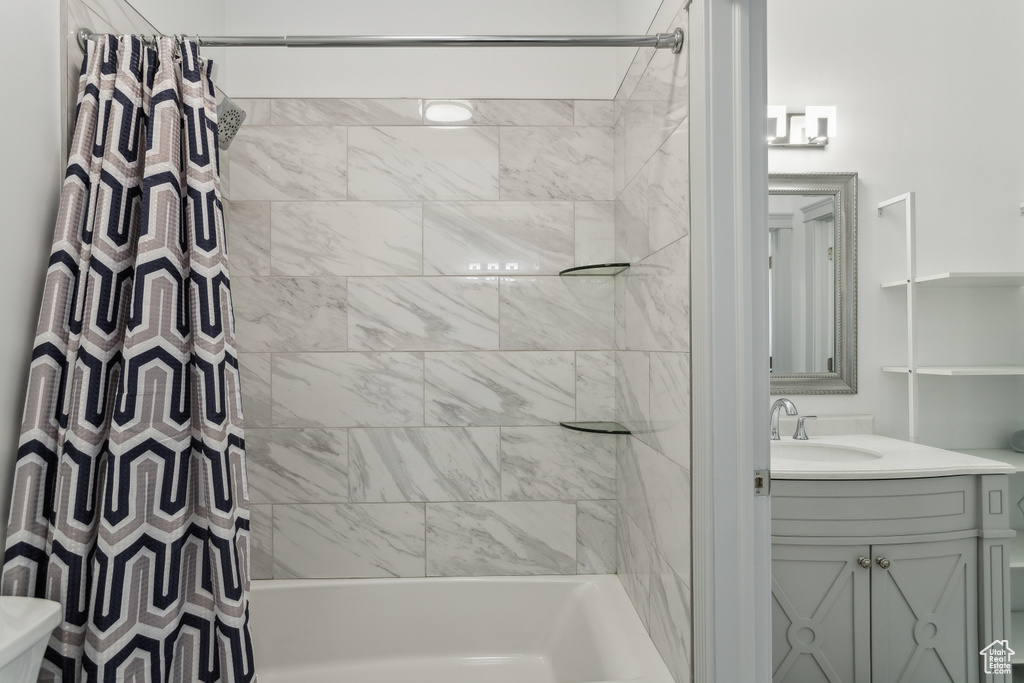 Bathroom featuring vanity, shower / bath combo, and toilet