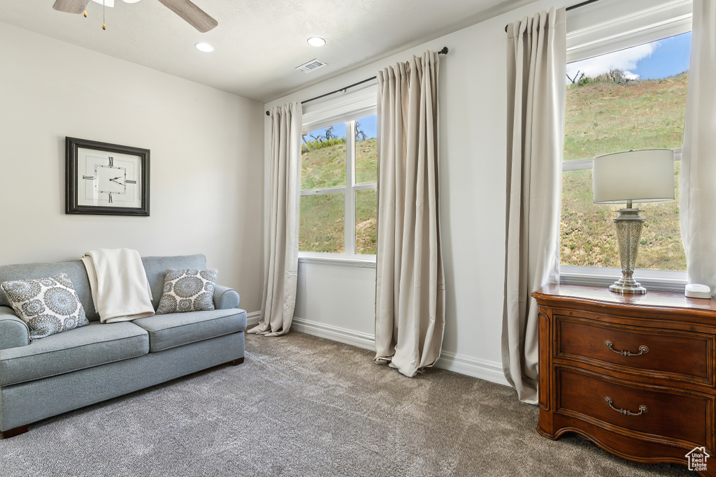 Carpeted living room featuring baseboards, ceiling fan, recessed lighting, and visible vents