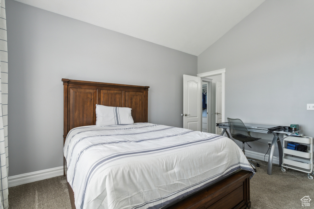 Carpeted bedroom with high vaulted ceiling and baseboards