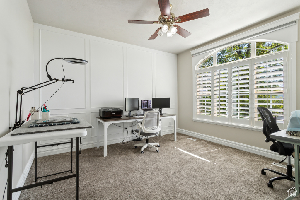 Home office featuring carpet floors, a ceiling fan, and baseboards