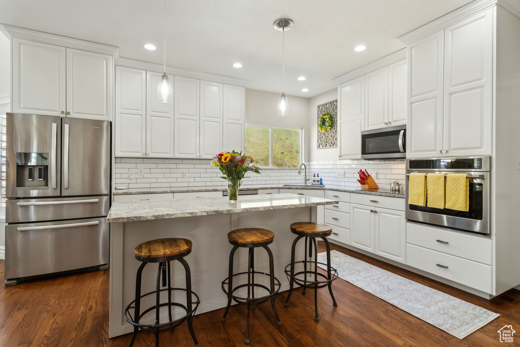 Kitchen featuring a sink, white cabinets, and stainless steel appliances
