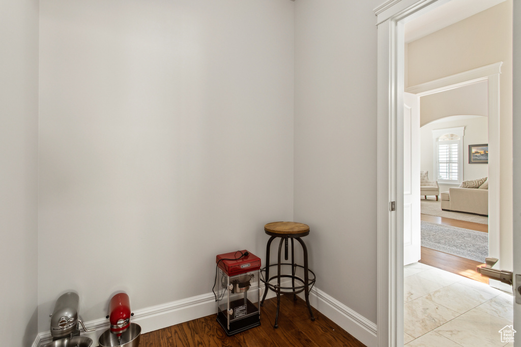 Interior space featuring arched walkways, baseboards, and wood finished floors