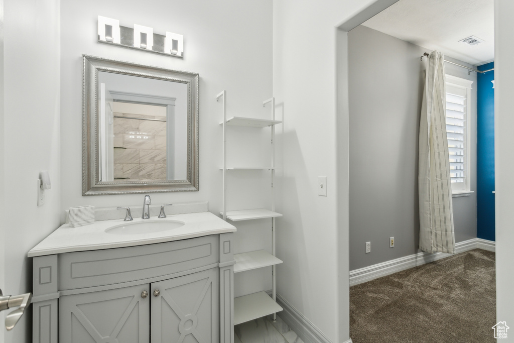 Bathroom featuring vanity, baseboards, and visible vents